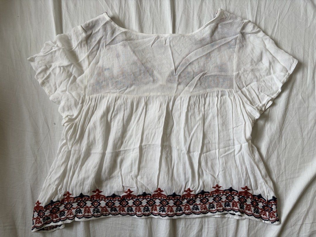 Forever 21 White Boho Embroidered Blouse (Category: Blouses) located in Quezon City. Submitted by vidadmarie (Listing ID 1469819027, Image 2). Description: - Brand/Model: Forever 21 - Size: Small (tag attached) - Details: V-neckline with tassel drawstrings and short flutter sleeves - Condition: Clean, well-maintained overall.