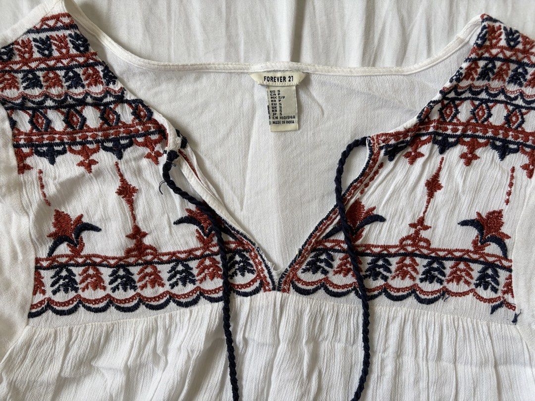 Forever 21 White Boho Embroidered Blouse (Category: Blouses) located in Quezon City. Submitted by vidadmarie (Listing ID 1469819027, Image 3). Description: - Brand/Model: Forever 21 - Size: Small (tag attached) - Details: V-neckline with tassel drawstrings and short flutter sleeves - Condition: Clean, well-maintained overall.