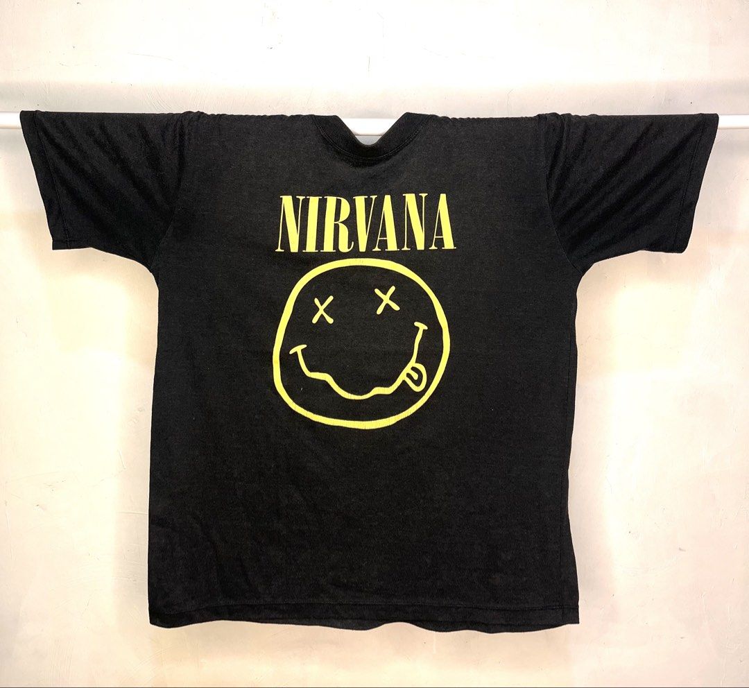 Gallery Dept. Nirvana Band Tee (Category: Tshirts & Polo Shirts ) located in Cavite. Submitted by ozzyozzx (Listing ID 1469881836, Image 1). Description: - Brand: Gallery Dept. - Design: Nirvana yellow smiley face graphic on front, band photo on back - Condition: Soft washed fabric with natural fading for a vintage aesthetic - Details: Blue neck tag with yellow embroidered lettering - Fit: Short sleeves, crew neckline - Color: Black - Mode of Pay