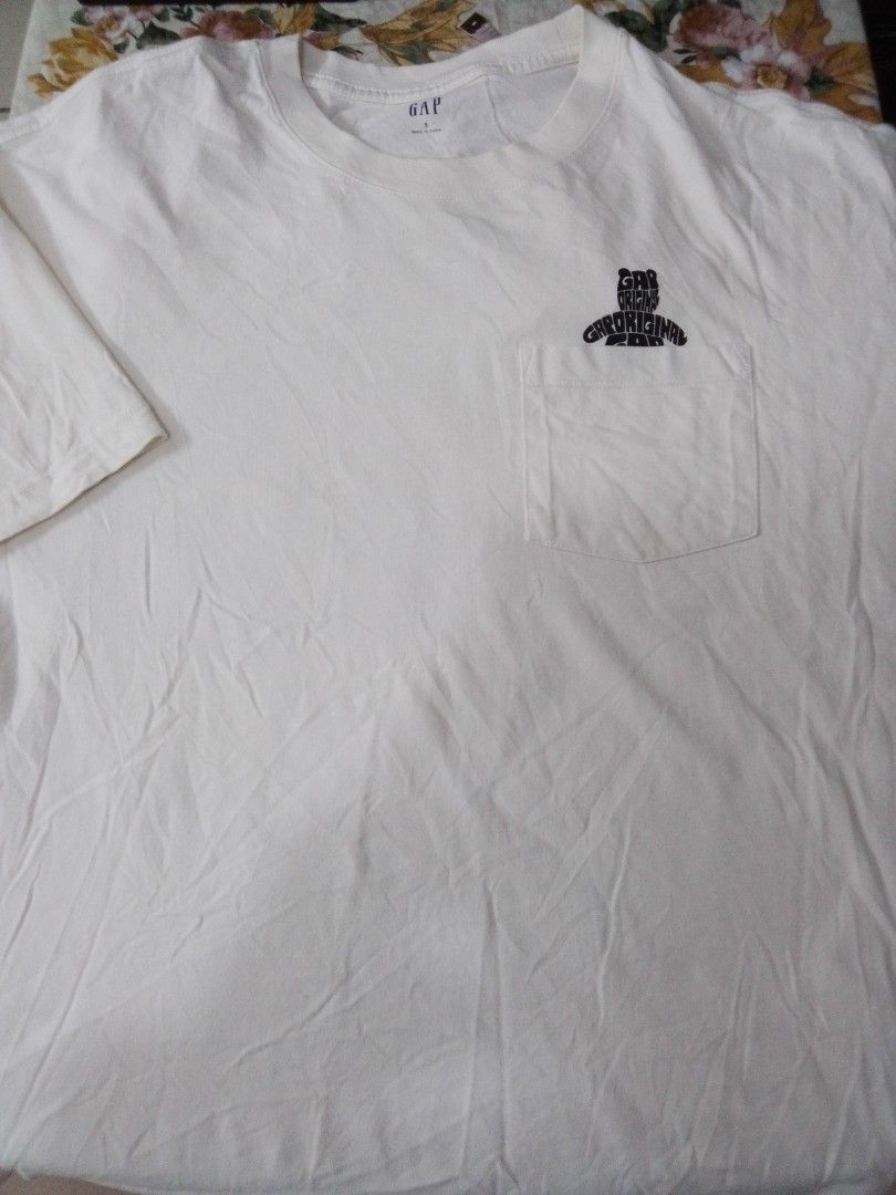 Gap Original Graphic White T-Shirt (Category: Shirts) located in Manila. Submitted by jctclthng_2026 (Listing ID 1469813737, Image 1). Description: - Brand: Gap - Color: White with black all-over typographic graphic - Design: Repeated 'Gap Original' stylized retro font into a best shaped logo - Fit & Style: Standard fit, short sleeves, crew neck - Material: Soft, lightweight, and breathable cotton - Condition: Minimal wear, need wash, no stains o