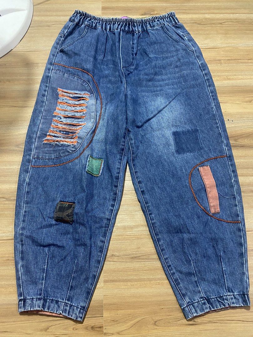 Garterized 25"-40" length 35.5" (Category: Jeans) located in Bulacan. Submitted by Spothings (Listing ID 1469862342, Image 1). Description: - Style: Relaxed, slouchy fit blue denim pants with elastic ankles - Waist: Comfortable elastic waistband for easy wear - Details: Distressed front patches with orange fringe, green square patch, and dark checkered accent - Back: Single patch pocket on the right side - Versatility: Perfect for pairing with yo