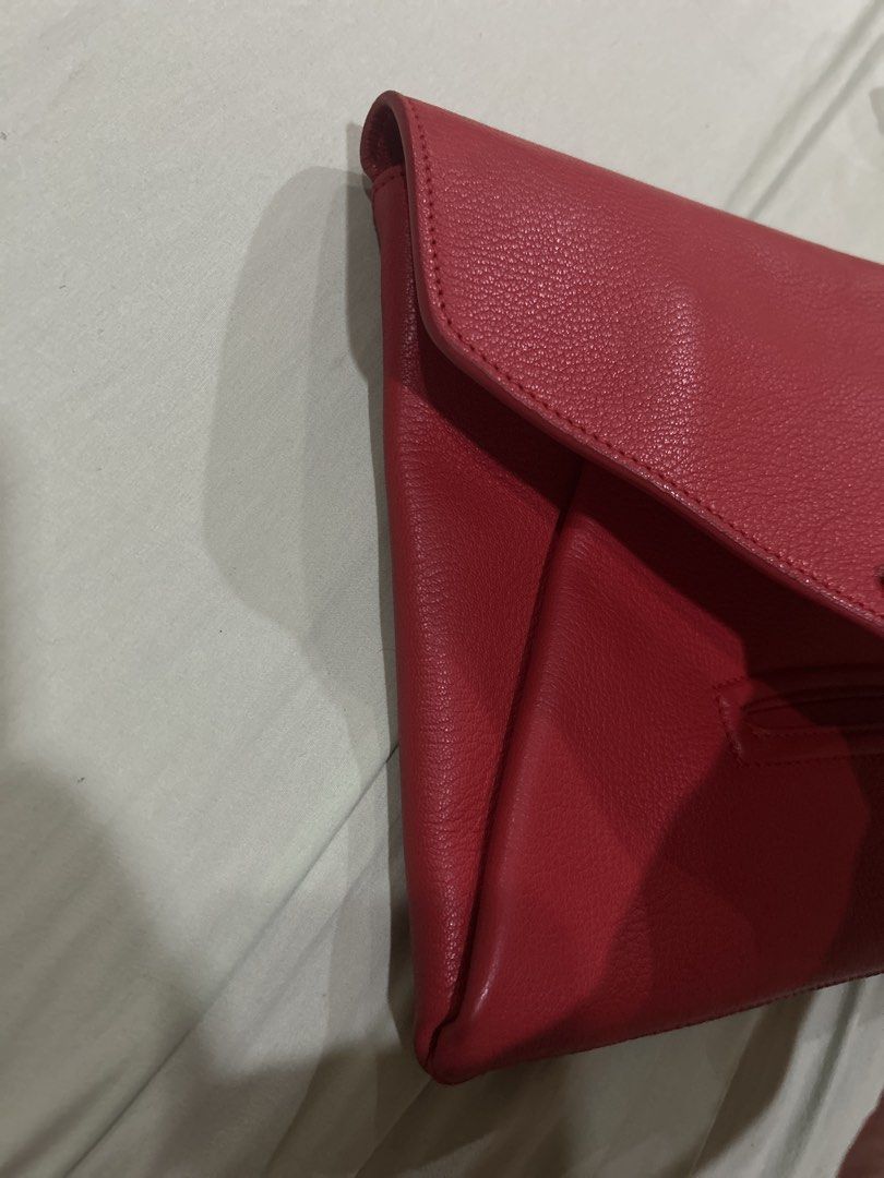 Givenchy Antigona Envelope Clutch in Red (Category: Luxury Bags & Wallets) located in Quezon City. Submitted by kateykate12345 (Listing ID 1469923129, Image 3). Description: - Brand: Givenchy - Material: red pebbled leather - Closure: Envelope flap with front metal branding - Interior: Black lining with 'Made in Italy' stamped leather tag - Condition: Clean exterior and corners - Inclusion: Comes with dust bag, authentication from Poizon - Negoti