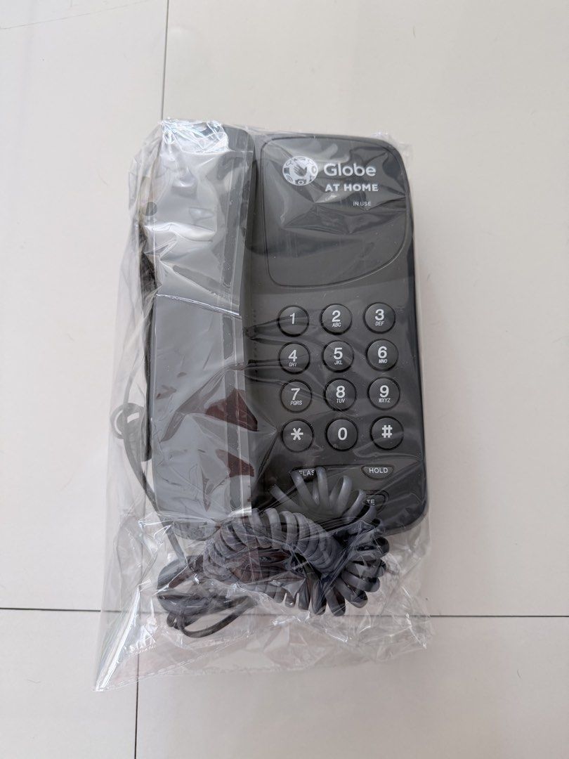 Globe At Home Landline Phone (Category: Office & Business Technology) located in Manila. Submitted by erin_closet (Listing ID 1469774503, Image 1). Description: - Brand new Globe At Home corded landline telephone in black - Still sealed in original clear plastic packaging - Standard keypad layout (0-9, *, #) - Equipped with convenient hold and flash buttons - Includes corded handset with a durable coiled black cord - Perfect for home or office us