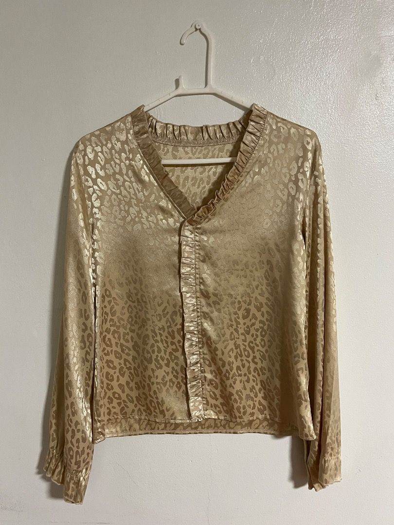 Gold Animal Print Blouse with Ruffled Collar (Category: Blouses) located in Cabuyao City. Submitted by rdtrmt (Listing ID 1469871936, Image 1). Description: - Gold satin blouse with all-over leopard print - Long sleeves featuring stylish ruffled cuffs - V-neckline with delicate ruffled trim - Lightweight, smooth fabric with a subtle metallic sheen - Versatile piece, perfect for work or night outs.