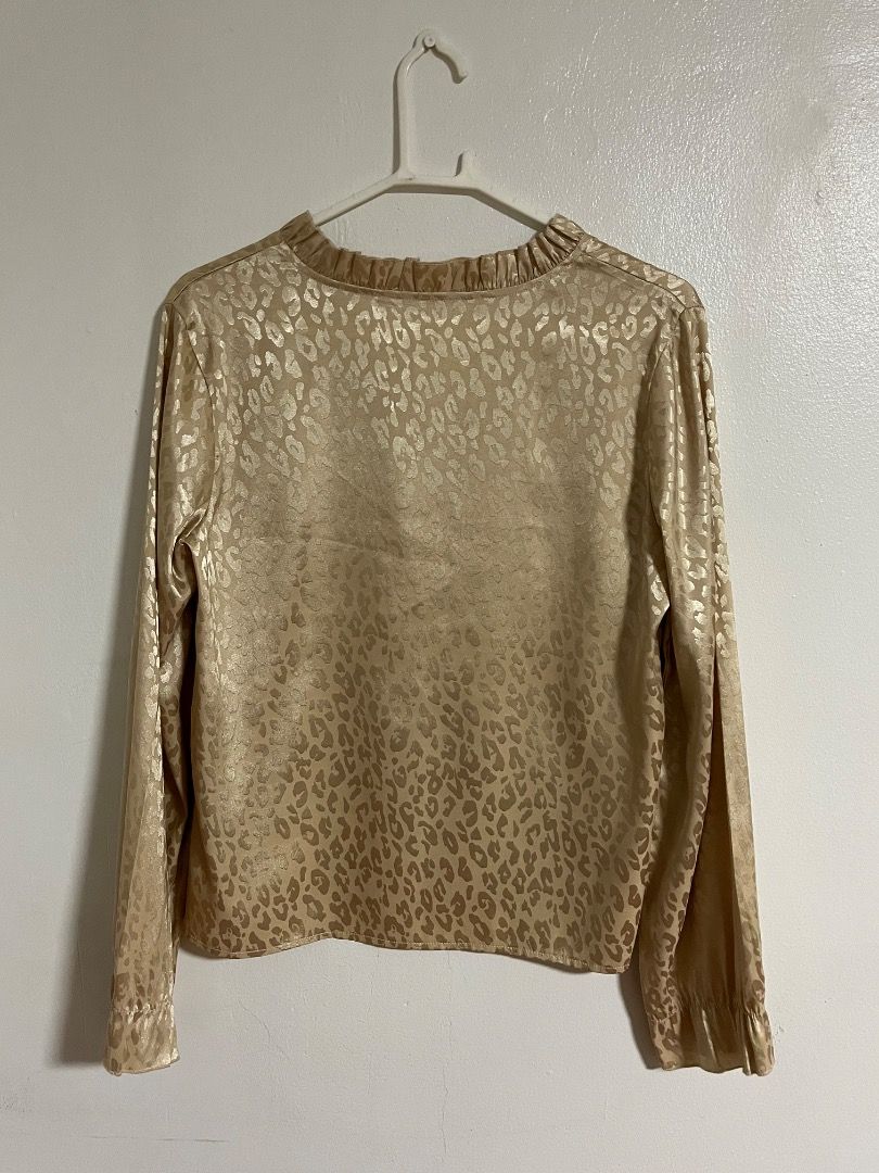 Gold Animal Print Blouse with Ruffled Collar (Category: Blouses) located in Cabuyao City. Submitted by rdtrmt (Listing ID 1469871936, Image 2). Description: - Gold satin blouse with all-over leopard print - Long sleeves featuring stylish ruffled cuffs - V-neckline with delicate ruffled trim - Lightweight, smooth fabric with a subtle metallic sheen - Versatile piece, perfect for work or night outs.