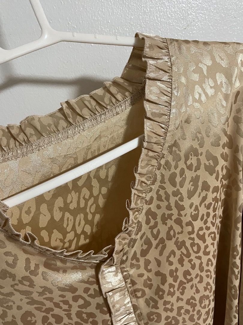 Gold Animal Print Blouse with Ruffled Collar (Category: Blouses) located in Cabuyao City. Submitted by rdtrmt (Listing ID 1469871936, Image 3). Description: - Gold satin blouse with all-over leopard print - Long sleeves featuring stylish ruffled cuffs - V-neckline with delicate ruffled trim - Lightweight, smooth fabric with a subtle metallic sheen - Versatile piece, perfect for work or night outs.
