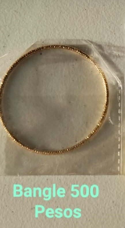 Gold-colored textured bangle bracelet (Category: Bracelets) located in Indang. Submitted by neb.thingz (Listing ID 1469902467, Image 1). Description: - Color: Gold - Style: Slim profile with textured outer detailing - Condition: Brand new, sealed in clear plastic packaging - Versatility: Perfect for daily outfits and casual looks.