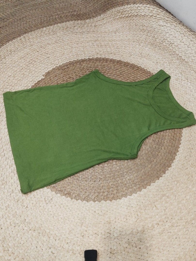 Green ribbed tank top sleeveless basic casual shirt (Category: Sleeveless) located in San Juan City. Submitted by rhennx (Listing ID 1469899193, Image 1). Description: - Color: Solid green - Material: Soft stretch fabric - Design: Ribbed texture, classic crew neckline, sleeveless cut - Styling: Versatile basic piece, great for layering or wearing on its own - Pairing: Easy to match with jeans, shorts, or skirts.