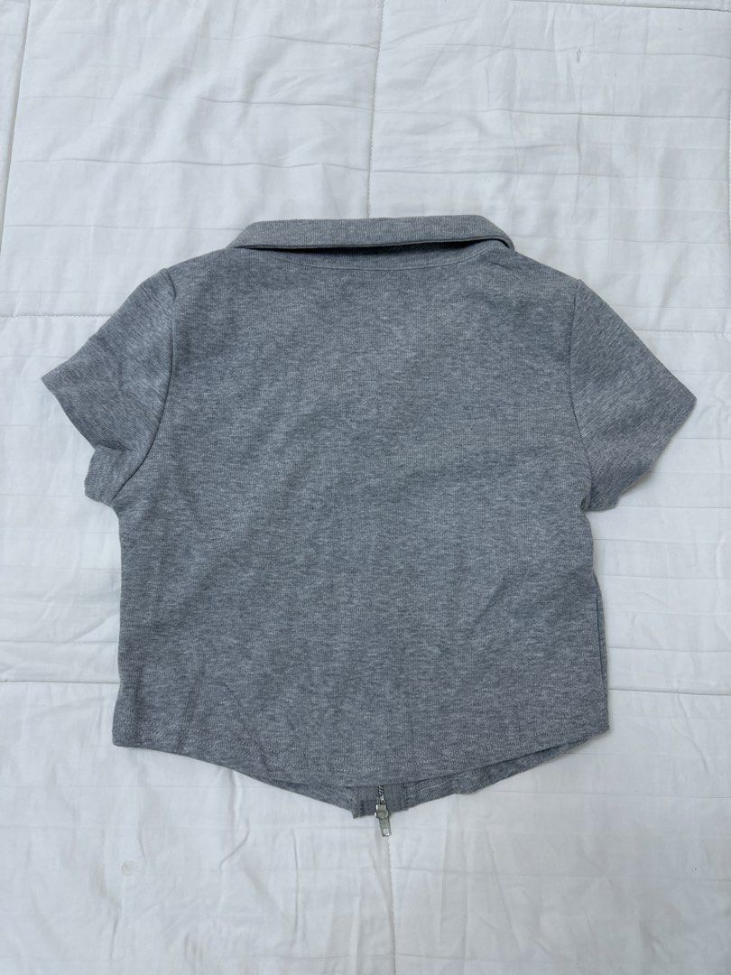 Grey Collared Zip Up Crop Top (Category: Sleeveless) located in Quezon City. Submitted by m3gan8 (Listing ID 1469787355, Image 2). Description: - Color: Grey - Style: Cropped top with collar and full front zipper - Sleeves: Short sleeves - Material: Soft, comfortable jersey - Design: Curved hemline, perfect with high-waisted jeans or skirts.
