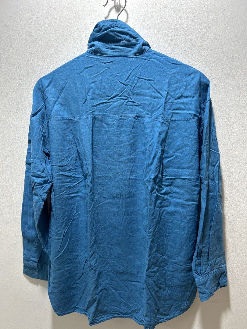 GU Blue Long Sleeve Button-Up Shirt (Category: Longsleeves) located in Manila. Submitted by isabelle_1104 (Listing ID 1469944107, Image 2). Description: - Color: Solid blue - Fit: Relaxed fit with classic collar and curved hem - Closure: Front button-up with matching buttons - Material: Lightweight woven fabric - Versatility: Perfect for casual outings or layering - Condition: Brand new / Excellent quality.