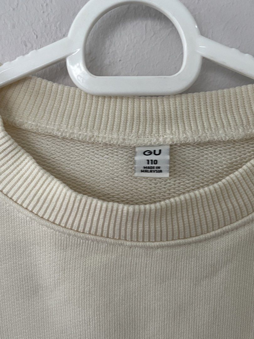 GU Cream Sweater Size 110 (Category: Babies & Kids Fashion) located in San Fernando. Submitted by wearvfs (Listing ID 1469900524, Image 3). Description: - Brand: GU - Color: Creamy off-white - Size: 110 - Chest Width: Approx. 42 cm - Material/Interior: Soft fleece lining with thick ribbed hem and cuffs - Condition: Clean, no stains, and no damage.