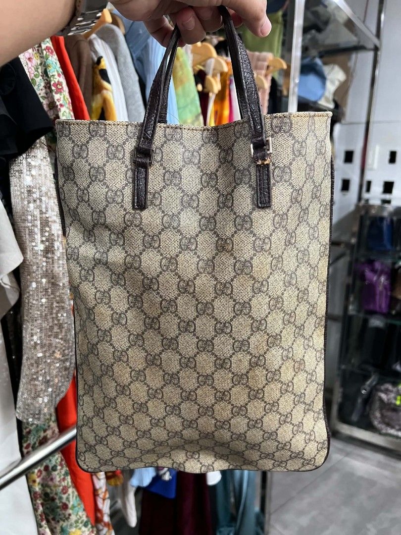 Gucci GG Monogram Canvas Tote Bag (Category: Luxury Bags & Wallets) located in Urdaneta. Submitted by jayceegarage (Listing ID 1469903906, Image 2). Description: - 100% Authentic Gucci monogram canvas tote in brown and beige - Premium dark brown textured leather trim with front logo patch - Secure magnetic snap button closure - Compact vertical rectangular shape for effortless everyday use - Double top handles for comfortable carrying.