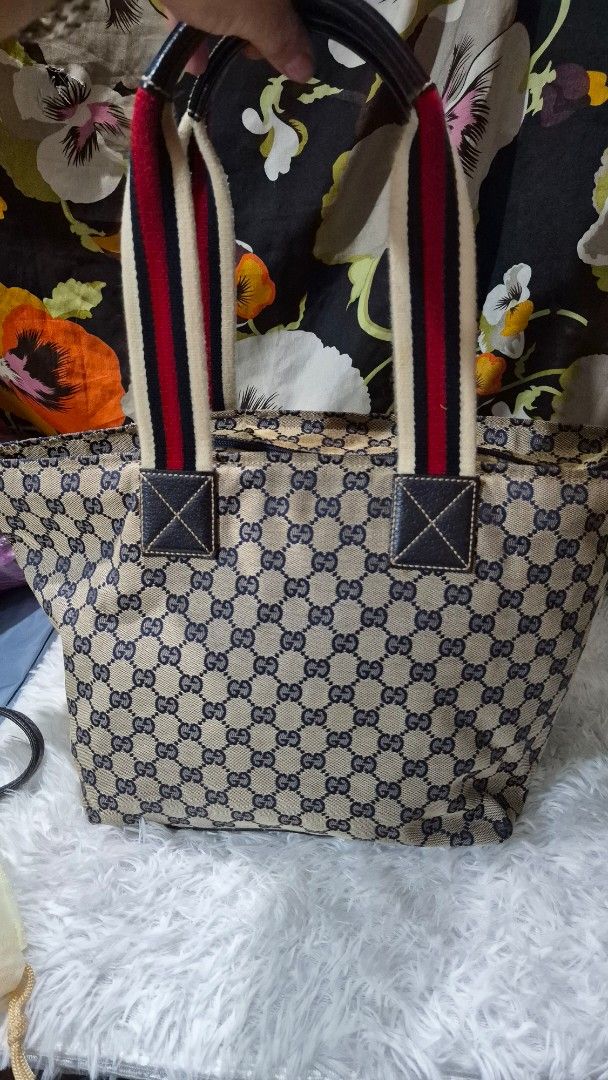 Gucci Monogram Tote Bag Blue Beige Canvas (Category: Luxury Bags & Wallets) located in Baguio. Submitted by jhaz_bags (Listing ID 1469901984, Image 1). Description: - Authentic Classic Gucci Tote Bag - Blue & beige GG monogram canvas with leather trim - Iconic red & white web stripe handles - Secure zip top closure - Spacious dark fabric-lined interior with zipper & slip pockets - Serial number stamped on interior leather tag - Perfect, roomy eve