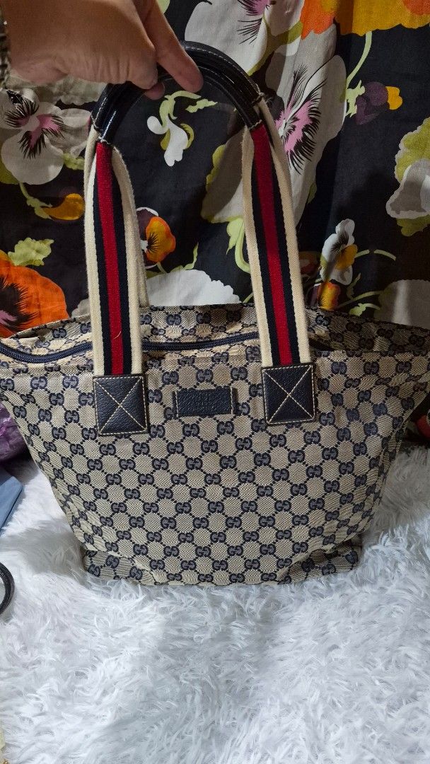 Gucci Monogram Tote Bag Blue Beige Canvas (Category: Luxury Bags & Wallets) located in Baguio. Submitted by jhaz_bags (Listing ID 1469901984, Image 2). Description: - Authentic Classic Gucci Tote Bag - Blue & beige GG monogram canvas with leather trim - Iconic red & white web stripe handles - Secure zip top closure - Spacious dark fabric-lined interior with zipper & slip pockets - Serial number stamped on interior leather tag - Perfect, roomy eve