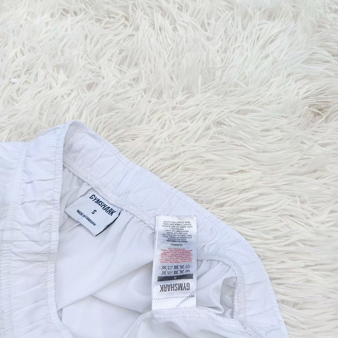 Gymshark White Shorts Size S (Category: Shorts) located in Gattaran. Submitted by thrift_wiseph (Listing ID 1469857090, Image 3). Description: - Brand: Gymshark - Color: Clean White - Size: Small - Material: 100% lightweight polyester - Features: Elastic waistband for a snug fit, printed sharkhead logo on lower left leg - Care: Easy to wash and maintain.