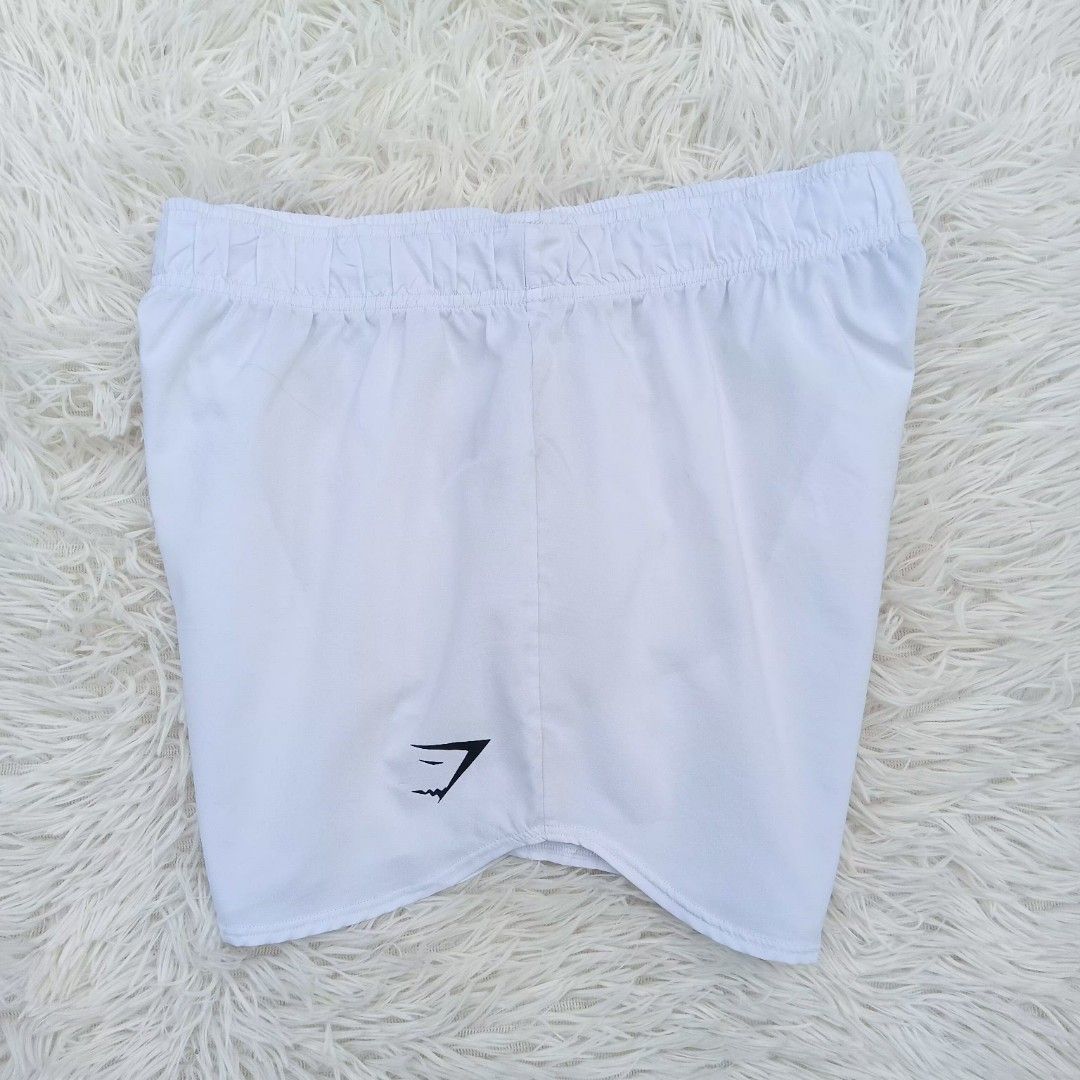Gymshark White Shorts Size S (Category: Shorts) located in Gattaran. Submitted by thrift_wiseph (Listing ID 1469857090, Image 1). Description: - Brand: Gymshark - Color: Clean White - Size: Small - Material: 100% lightweight polyester - Features: Elastic waistband for a snug fit, printed sharkhead logo on lower left leg - Care: Easy to wash and maintain.