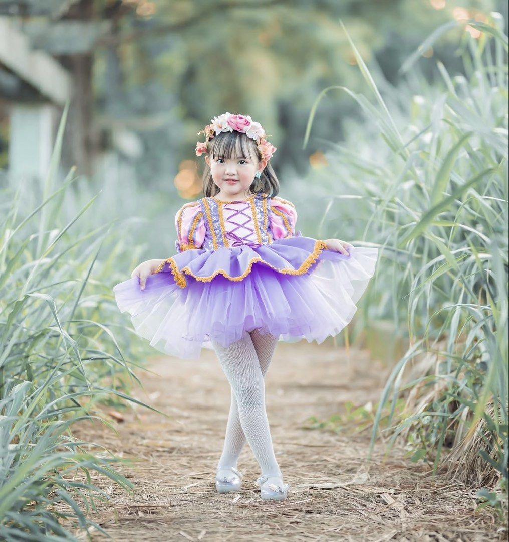 Hailey & Co Rapunzel Dress (Category: Babies & Kids Fashion) located in Dinalupihan. Submitted by loved.by.jin (Listing ID 1469772304, Image 1). Description: - Stunning purple and pink princess dress - Puffed sleeves with elegant gold trim - Corset-style pink bodice featuring criss-cross ribbon - Fluffy layered tulle skirt with gold lace edging - Ideal for parties, dress-up days, and photoshoots - Clean fabric, well-maintained, and ready to wear.