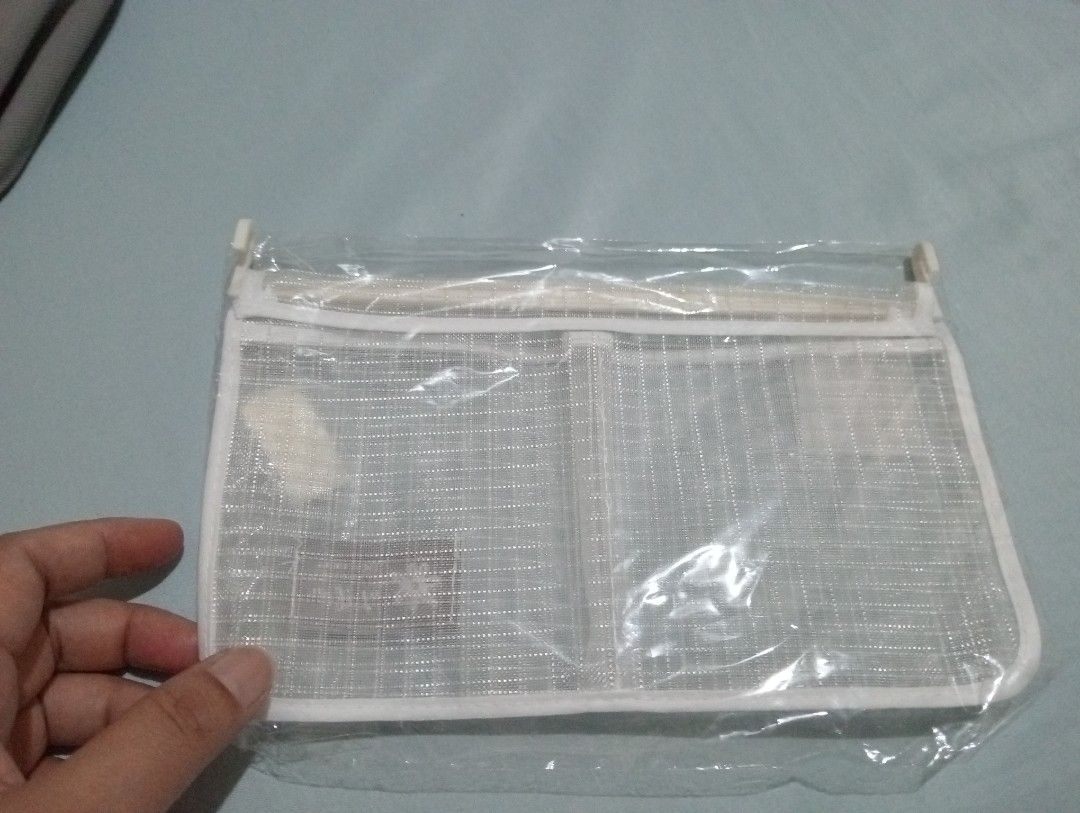 hanging storage bag organizer (Category: Food Organization & Storage) located in Makati City. Submitted by YSL80022 (Listing ID 1469887648, Image 2). Description: - Color: White with grid pattern - Features: Secure zipper closure, 2 handy front pockets, and top plastic hanging clips - Material: Durable mesh fabric - Condition: Brand new, still in original clear plastic packaging - Perfect for organizing small items, cosmetics, or accessories RFS: