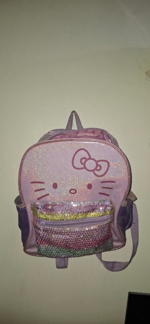Hello Kitty Sequin Pocket Mini Backpack Purple (Category: Babies & Kids Fashion) located in Manila. Submitted by ahuwvwubaiqn2owe (Listing ID 1469878753, Image 1). Description: - Design: Purple sparkly mini backpack featuring Kitty - Pocket: Colorful sequin front zipper pocket - Straps: Adjustable back straps for comfort - Capacity: Compact size, ideal for daily essentials - Condition: Brand new/Excellent - Perfect for: Sanrio fans and gifts.