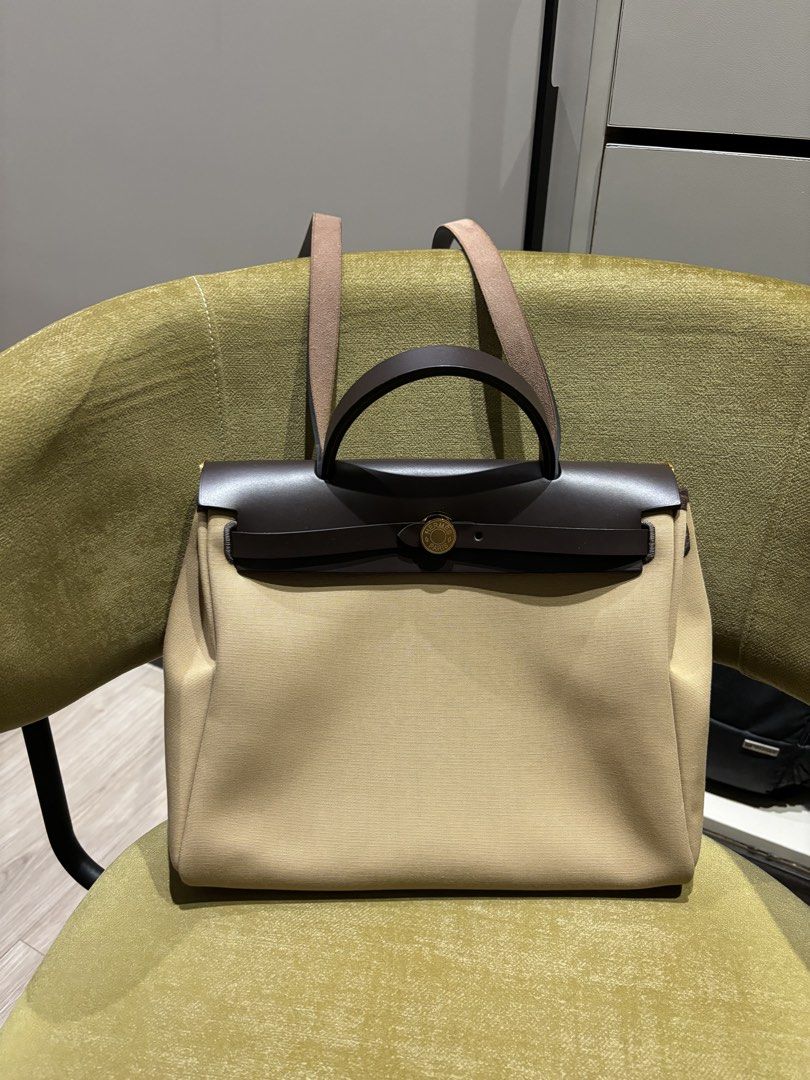 Hermes Herbag 31 Trench/Ebene Ghw (Category: Luxury Bags & Wallets) located in Quezon City. Submitted by foreverythingsss (Listing ID 1469760631, Image 1). Description: - Brand: Hermes - Material: Beige canvas and dark brown leather - Hardware: Gold-tone with classic turn-lock front flap closure - Carry options: Top carry handle and comfortable shoulder straps - Pockets: Exterior back zipper pocket and interior zipped compartment - Extras: Includ