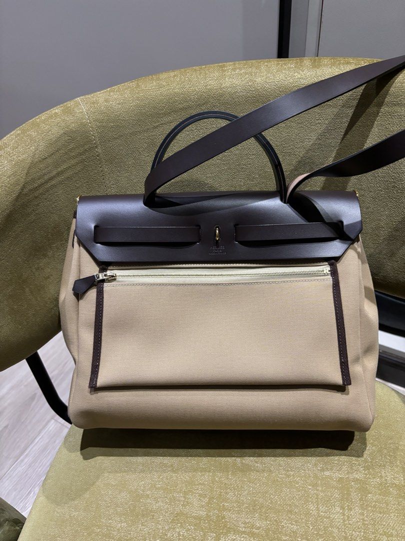 Hermes Herbag 31 Trench/Ebene Ghw (Category: Luxury Bags & Wallets) located in Quezon City. Submitted by foreverythingsss (Listing ID 1469760631, Image 2). Description: - Brand: Hermes - Material: Beige canvas and dark brown leather - Hardware: Gold-tone with classic turn-lock front flap closure - Carry options: Top carry handle and comfortable shoulder straps - Pockets: Exterior back zipper pocket and interior zipped compartment - Extras: Includ