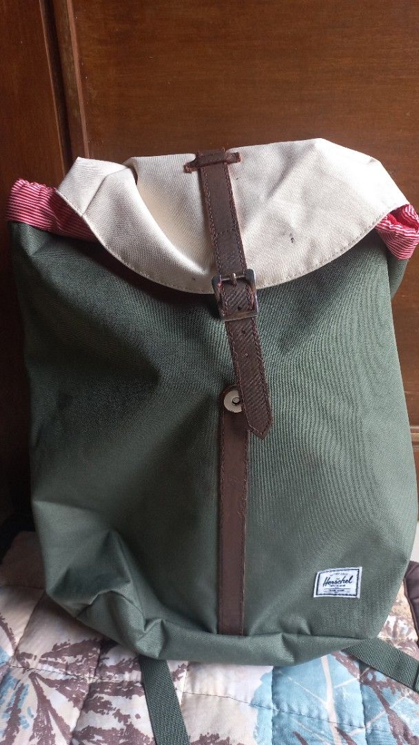 Herschel Green Backpack with Cream Flap and Straps (Category: Backpacks) located in Rizal. Submitted by mayra74 (Listing ID 1469945299, Image 1). Description: - Brand: Herschel - Color: Green canvas with cream top flap and brown faux leather straps - Closure: Metal buckle closure - Interior: Red and white striped lining with an inner pocket and Herschel brand tag - Straps: Adjustable shoulder straps for a comfortable fit - Condition: Super clean 