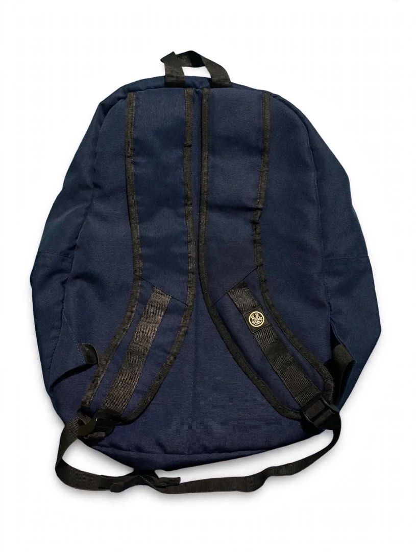 HGHMNDS Navy Blue Red Backpack (Category: Backpacks) located in Quezon City. Submitted by un0oo (Listing ID 1469923795, Image 2). Description: Navy blue backpack with a contrasting red front pocket. Two black woven labels featuring the HGHMNDS logo on the front. Adjustable black shoulder straps. Main compartment zips closed. Front zipped pocket keeps smaller items organized. Sturdy canvas material throughout..