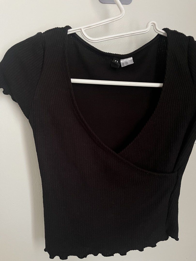 H&M Black Ribbed Wrap Top (Category: Sleeveless) located in Lapu Lapu. Submitted by alexisdeclutters (Listing ID 1469788437, Image 2). Description: - Brand: H&M - Size: XXS - Color: Black - Material: Stretchy, comfortable ribbed fabric - Design: Deep V-neck wrap front with short sleeves - Detail: Trendy lettuce hem edges - Styling: Perfect to match with high-waisted jeans or skirts.