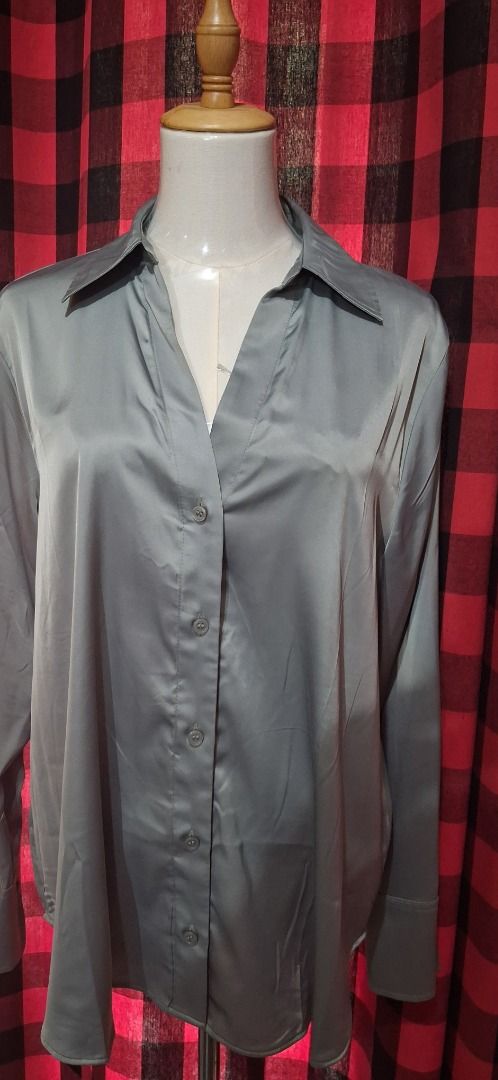 H&M Grey V-Neck Button-Down Blouse (Category: Blouses) located in Manila. Submitted by katkween23 (Listing ID 1469765486, Image 2). Description: - Brand: H&M - Size: M - Color: Grey - Material: Smooth satin-like fabric - Design: Deep V-neckline, classic collar, and long sleeves with wide cuffs - Condition: Clean, no flaws noticed - Versatility: Perfect for office wear or dressed down with jeans.