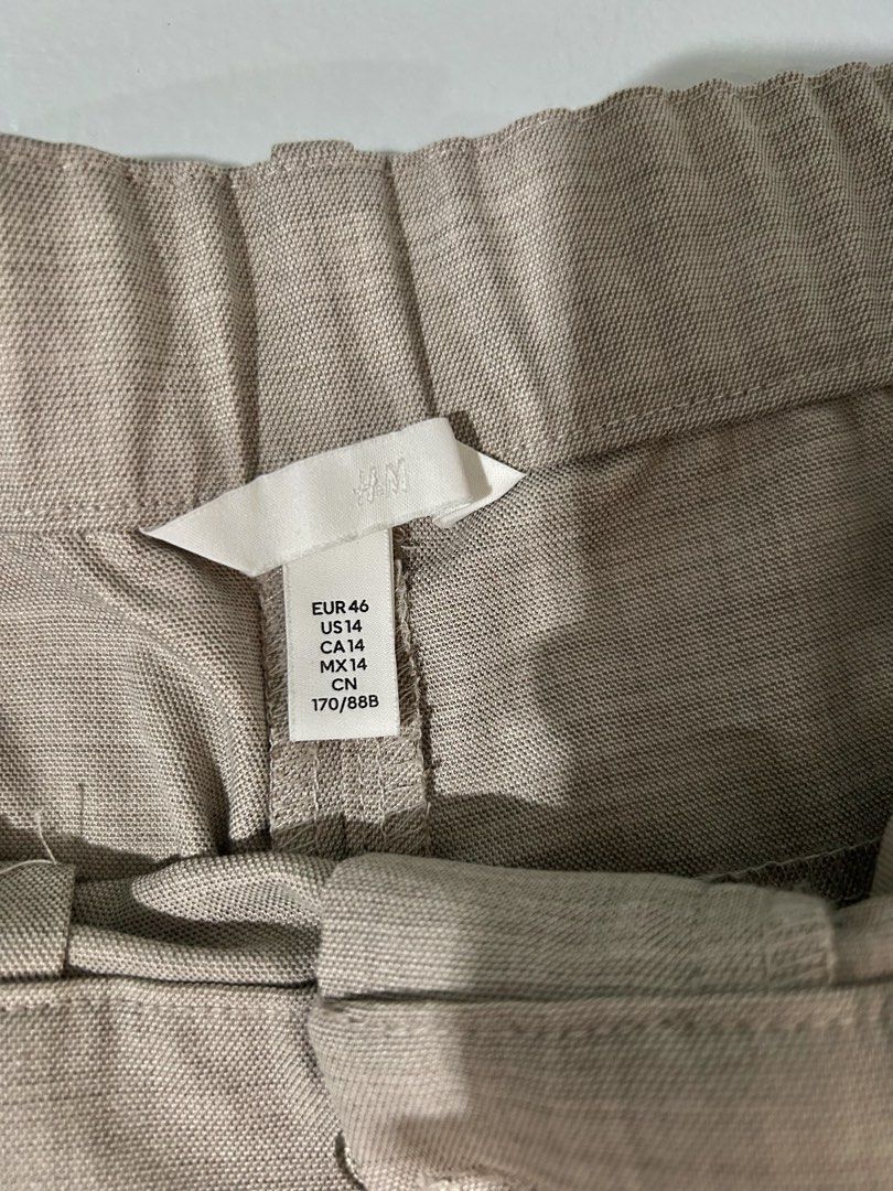 H&M Mocha Grey Pleated Pants/ Trousers (Category: Other Bottoms) located in Cainta. Submitted by unboxingstuff (Listing ID 1469816791, Image 3). Description: - Brand/Item: H&M Mocha Grey Pleated Trousers - Size: US 14, EUR 46 - Waist measurement: ~15 inches (flat lay) - Details: Mid-rise waist, belt loops, zip fly, two side pockets - Fabric: Structured with a slight texture - Condition: Clean, minimal wear, well-maintained - Perfect for smart cas