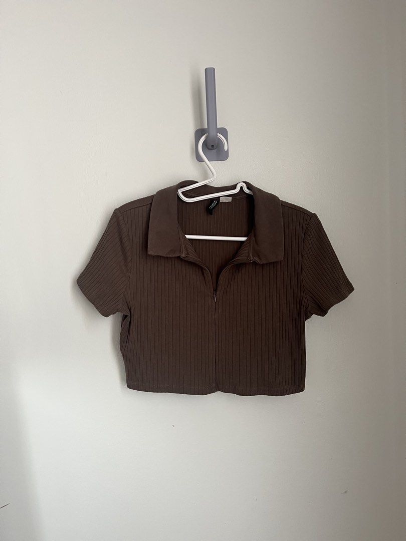 H&M Ribbed Top (Category: Shirts) located in Lapu Lapu. Submitted by alexisdeclutters (Listing ID 1469787663, Image 1). Description: - Large on tag but boxy fit on small frame - Brand: H&M - Color: Brown - Style: Ribbed crop top with short sleeves and polo collar - Details: Zip-up front neckline - Material: Stretchy, comfortable knit fabric - Condition: Like new, washed only a couple of times with zero flaws or fading.