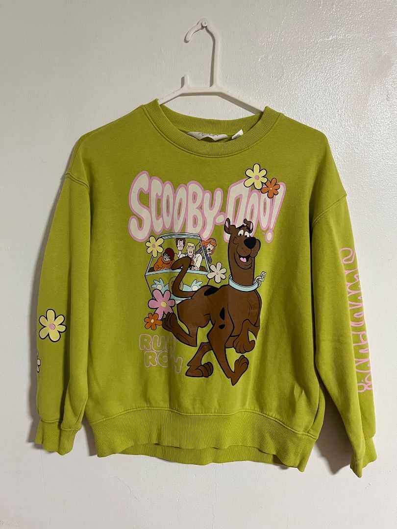 H&M Scooby-Doo Green Sweatshirt (Category: Coats, Jackets and Outerwear) located in Cabuyao City. Submitted by rdtrmt (Listing ID 1469868172, Image 1). Description: - Brand: H&M (Official Warner Bros tag) - Design: Green sweatshirt with Scooby-Doo graphic, pink lettering, and flower details - Size: EUR 146/152 (US 12/14, CA 10-12A, CN 150/76, MX 10-12, AUS 11-12, UK 10-12Y) - Material: Comfortable cotton blend with ribbed neckline and cuffs - Loo