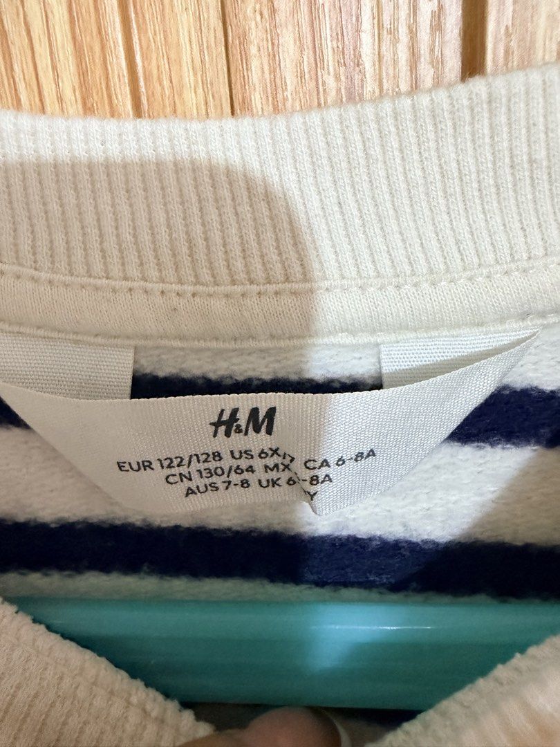 H&M Striped Sweatshirt Size 6-8Y (Category: Babies & Kids Fashion) located in Makati City. Submitted by ziagabrielle (Listing ID 1469766105, Image 3). Description: - Brand: H&M - Size: EUR 122/128, US 6X, UK 6-8A - Design: Classic blue and white horizontal stripes, crew neck - Details: Ribbed cuffs and hem, soft cotton blend material - Condition: Great, clean condition, perfect for everyday layering.