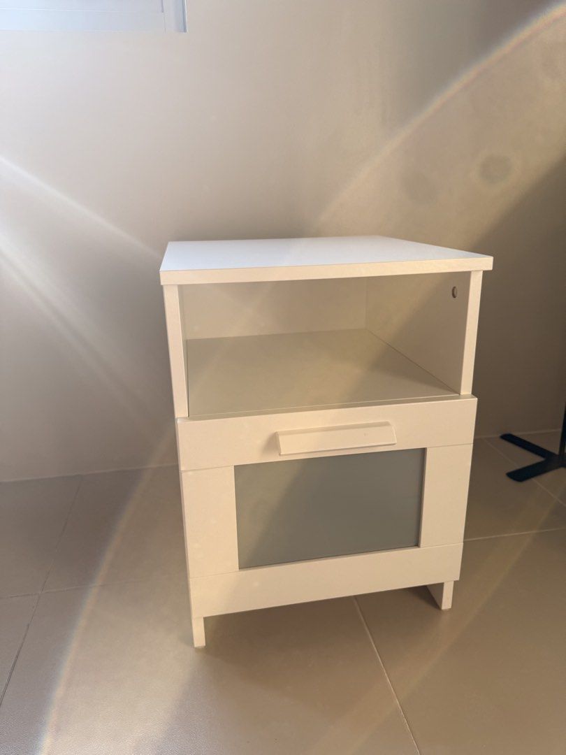 IKEA Nightstand White (Category: Shelves, Cabinets & Racks) located in Quezon City. Submitted by keenflower_35e25a (Listing ID 1469819880, Image 2). Description: - Authentic IKEA BRIMNES white nightstand - Dimensions: 39x41x53 cm - Features a convenient open top compartment and one lower drawer - Stylish frosted glass panel insert on the drawer - Clean, modern design that fits any bedroom setup.