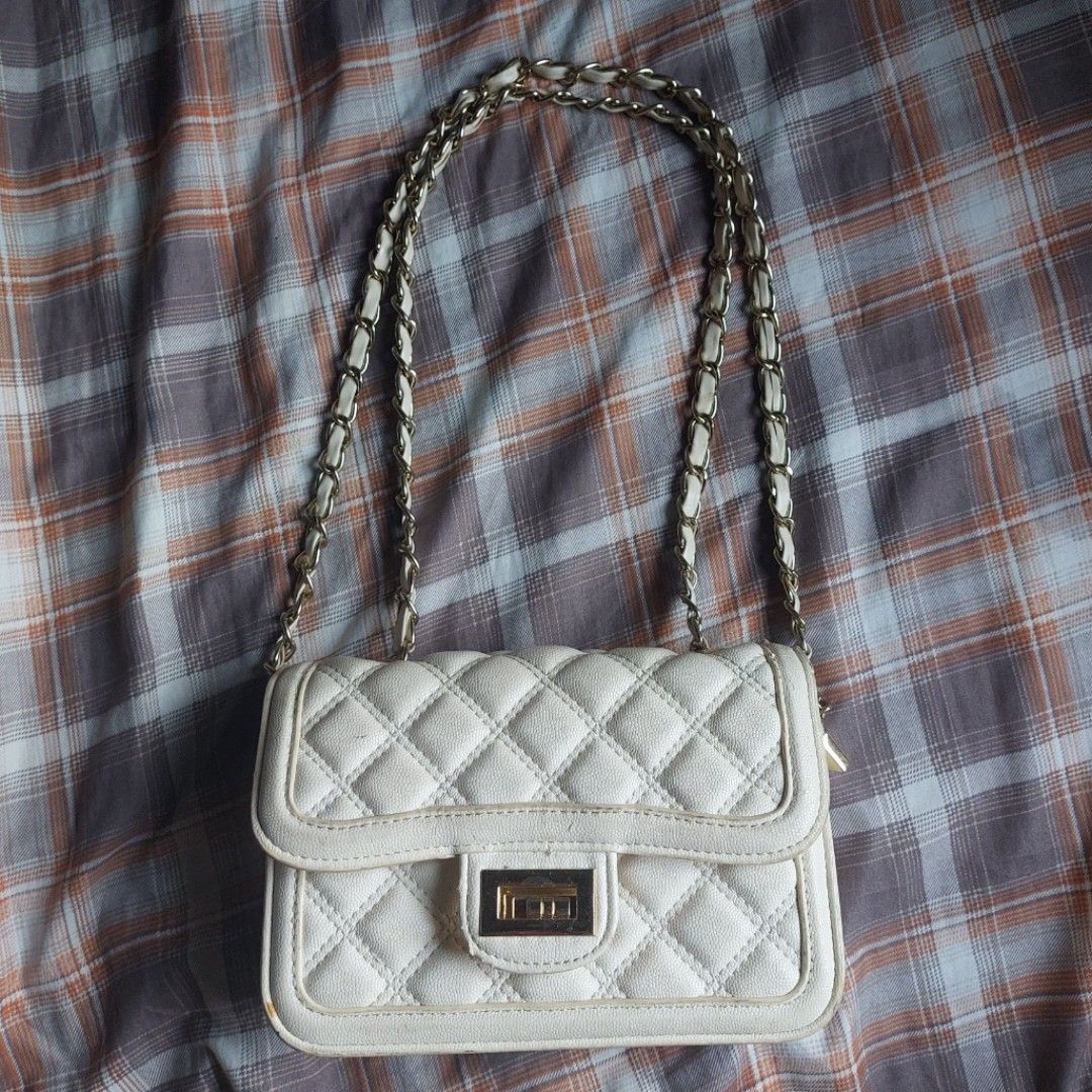 Jaod White Quilted Shoulder Bag with Gold Chain (Category: Shoulder Bags) located in Manila. Submitted by youresovaiineee (Listing ID 1469846850, Image 1). Description: - Material: White quilted faux leather with a structured, sturdy shape - Strap: Gold chain strap intertwined with white material - Closure: Secure front flap with a twist lock - Interior: Clean compartments lined in red with a convenient zipper pocket - Condition: Excellent and we