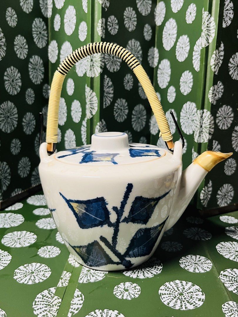 Japanese Ceramic Teapot with Bamboo Handle and Leaf Pattern (Category: Coffee & Tea Tableware) located in Malabon City. Submitted by mgsurplus (Listing ID 1469772316, Image 1). Description: - Material: White ceramic with blue leaf pattern - Handle: Securely attached wrapped bamboo handle - Spout: Ceramic with a distinct yellow-tinted tip - Lid: Matching lid with a small central knob included - Size: Handheld, ideal for single servings or small te