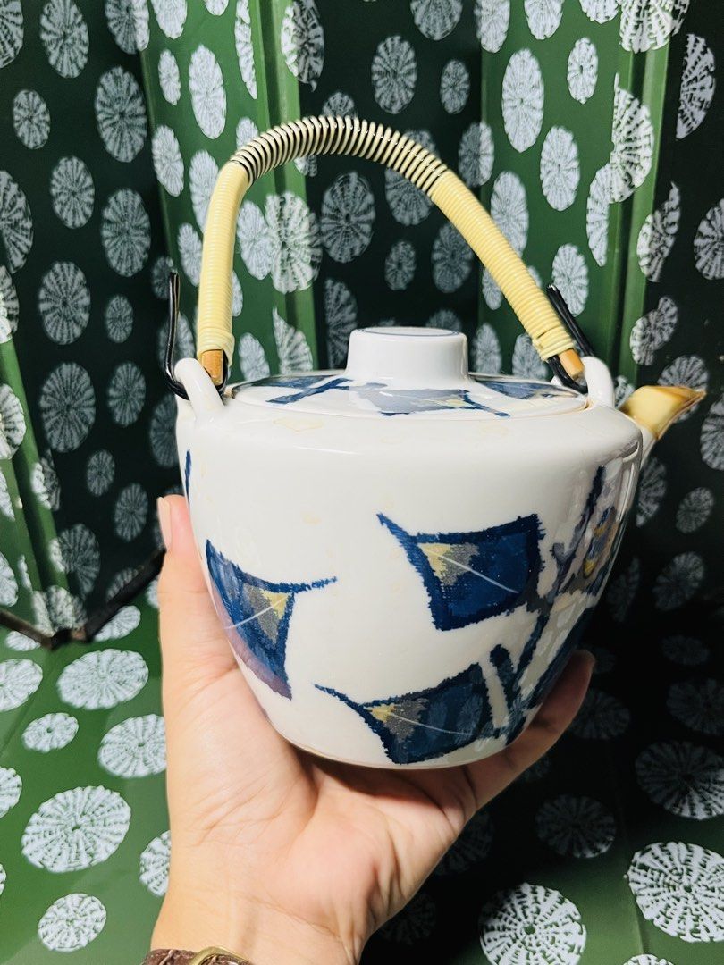 Japanese Ceramic Teapot with Bamboo Handle and Leaf Pattern (Category: Coffee & Tea Tableware) located in Malabon City. Submitted by mgsurplus (Listing ID 1469772316, Image 2). Description: - Material: White ceramic with blue leaf pattern - Handle: Securely attached wrapped bamboo handle - Spout: Ceramic with a distinct yellow-tinted tip - Lid: Matching lid with a small central knob included - Size: Handheld, ideal for single servings or small te