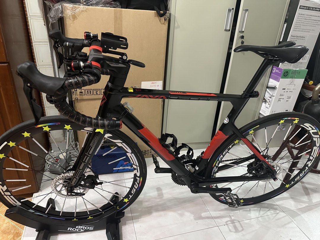 Java Decaf Road Bike (Category: Bicycles) located in Singapore. Submitted by naymintarya1993a4 (Listing ID 1469797652, Image 3). Description: - Brand/Model: Java Decaf Road Bike - Color: Black and red - Handlebars: Drop bars with black tape and integrated aero stem - Brakes: Dual disc brakes for reliable stopping power - Wheels: Deep section rims with Super Fast branding and reflective star stickers - Condition: Clean frame and well-maintained dr