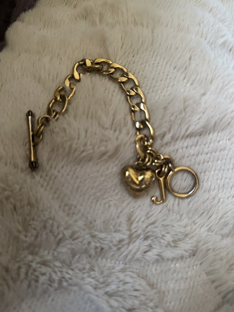 Juicy Couture Gold Charm Toggle Bracelet (Category: Bracelets) located in Manila. Submitted by declutterthisandthat (Listing ID 1469787078, Image 1). Description: - Authentic Juicy Couture gold-tone chain bracelet - Features signature puffed heart, letter J, and circle ring charms - Secure toggle bar closure - Classic chunky link design in standard bracelet length - Versatile piece, great for stacking or standalone wear.