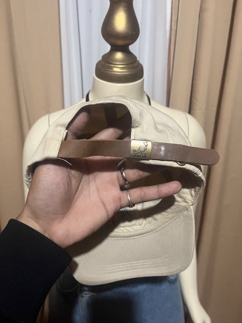 Kangol Beige Baseball Cap with Leather Strap (Category: Caps & Hats) located in Kidapawan. Submitted by azythrift (Listing ID 1469939171, Image 3). Description: - Authentic Kangol baseball cap in classic beige - Iconic embroidered kangaroo logo on the front - Made from durable cotton twill with breathable eyelets - Adjustable brown leather strapback with metallic buckle - Clean interior lining with official branded tag - Versatile everyday access