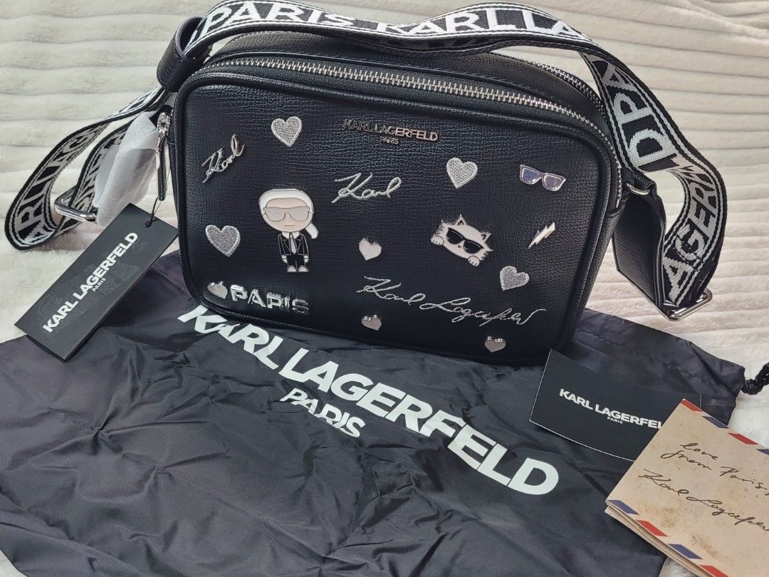 Karl Lagerfeld Paris Black Leather Camera Bag (Category: Cross-body Bags) located in Bocaue. Submitted by thewardrobehub (Listing ID 1469942893, Image 3). Description: 100% authentic and brand new!! Black pebble leather camera bag covered in silver patches, pins, and signatures. Karl Lagerfeld character graphic and Choupette cat face on the front. Double zip top closure with black and white logo webbing strap. It comes with Karl Lagerfeld dust ba
