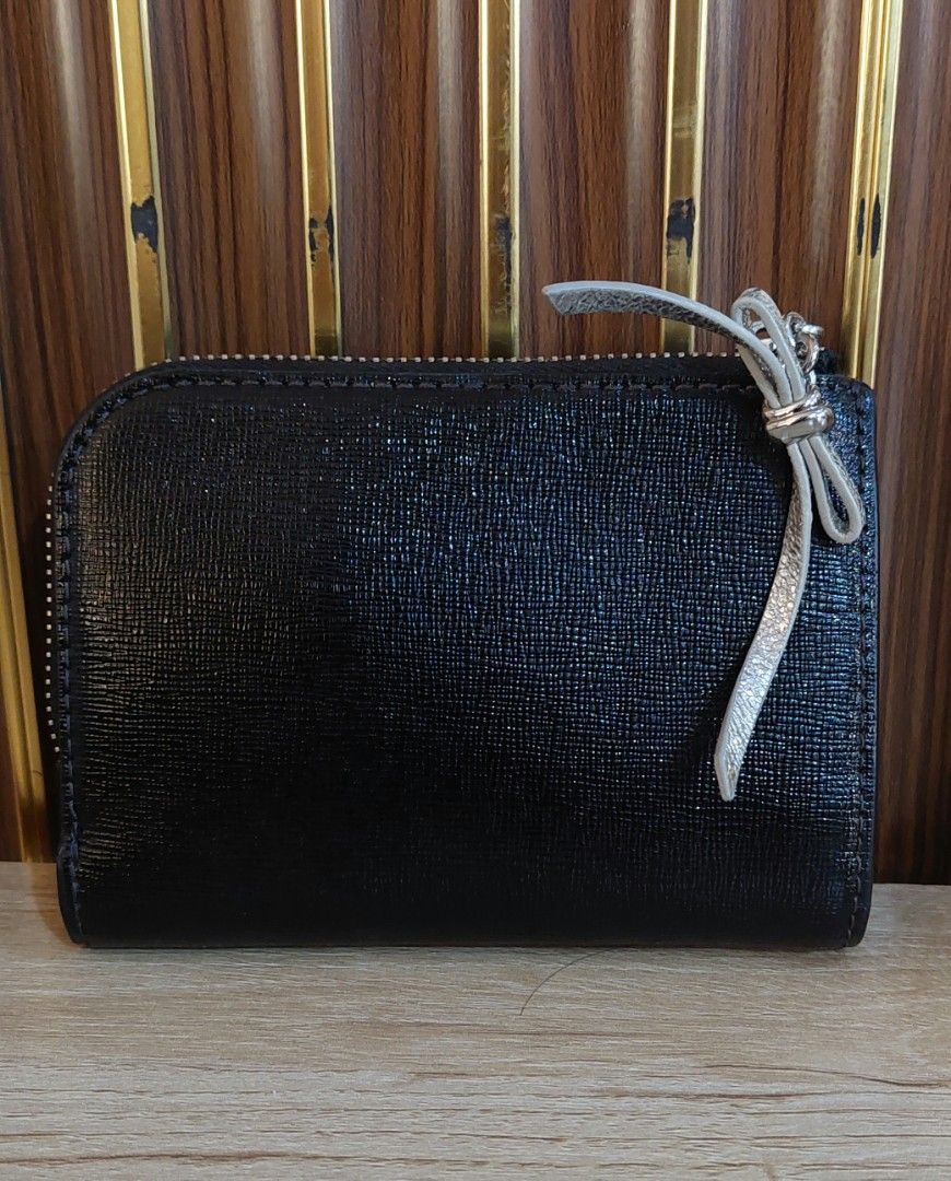 Kate Spade New York Cat Print Wallet (Category: Wallets & Card holders) located in Taguig. Submitted by thrifthub.ph (Listing ID 1469780669, Image 2). Description: - Brand: Kate Spade New York - Material: Genuine black leather - Design: White Persian cat graphic with metallic pink glitter bow - Hardware: Silver-tone with metallic bow zipper pull - Interior: Signature logo lining, multiple card slots, and top zipped coin compartment - Size: Compac