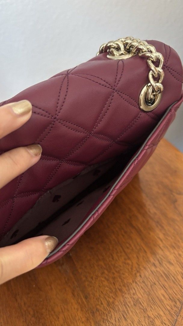 Kate Spade Quilted Maroon Leather Shoulder Bag (Category: Luxury Bags & Wallets) located in Alaminos. Submitted by doc_helenpretty99 (Listing ID 1469801006, Image 3). Description: - Brand: Kate Spade - Color: Burgundy - Material: Quilted leather - Hardware: Gold-tone - Closure: Turnlock front flap - Pockets: Interior compartments and back slip pocket - Details: Signature spade-pattern interior lining, chain straps with leather shoulder guard - Co