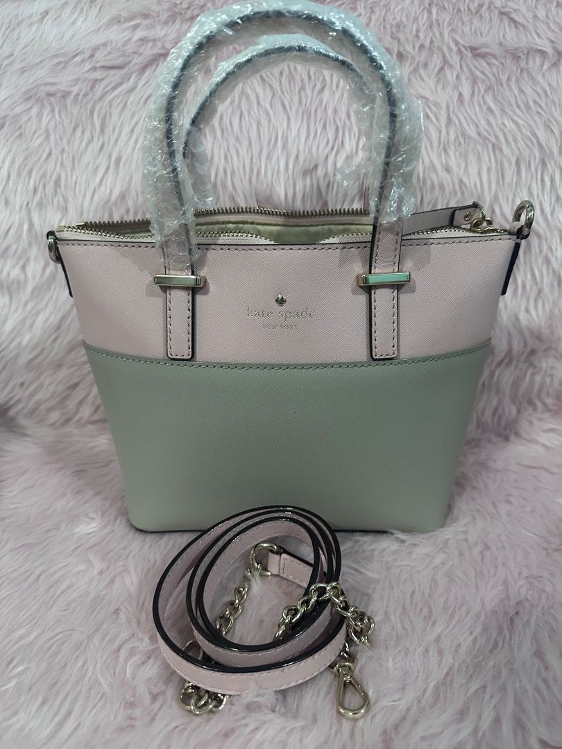 Kate Spade Two-Tone Pink and Gray Handbag (Category: Luxury Bags & Wallets) located in Caloocan City. Submitted by shaunshan (Listing ID 1469833576, Image 2). Description: - Color: Two-tone light pink and gray - Hardware: Gold tone with front logo lettering - Closure: Secure zip top - Handles: Dual top handles (still wrapped in plastic) - Strap: Detachable shoulder strap with stylish gold chain links - Structure: Compact with a flat bottom base -
