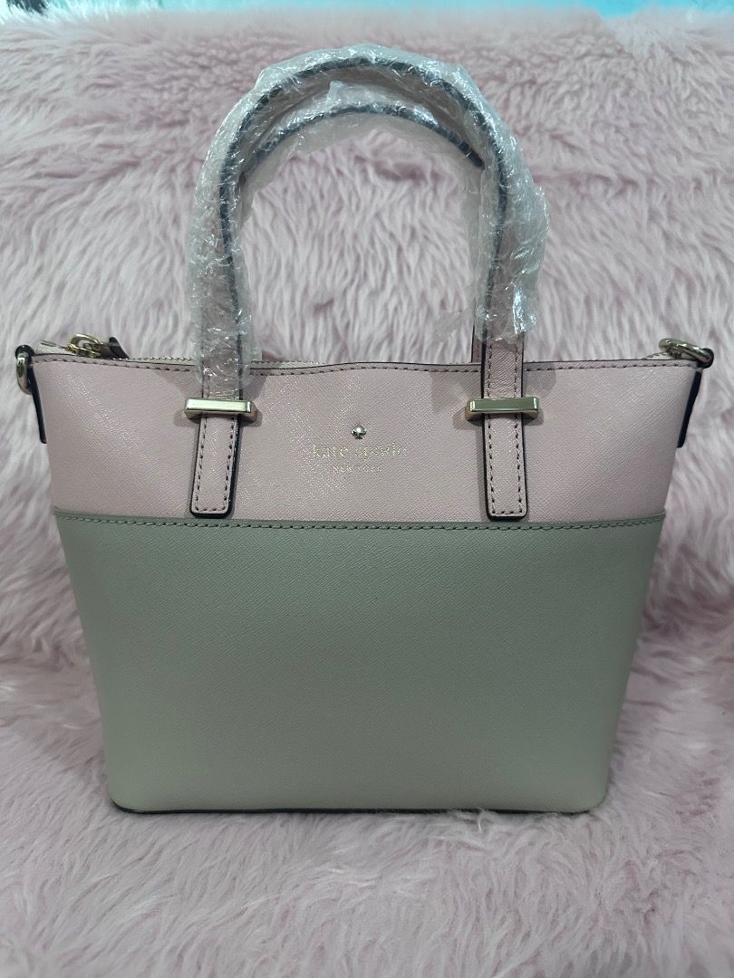 Kate Spade Two-Tone Pink and Gray Handbag (Category: Luxury Bags & Wallets) located in Caloocan City. Submitted by shaunshan (Listing ID 1469833576, Image 3). Description: - Color: Two-tone light pink and gray - Hardware: Gold tone with front logo lettering - Closure: Secure zip top - Handles: Dual top handles (still wrapped in plastic) - Strap: Detachable shoulder strap with stylish gold chain links - Structure: Compact with a flat bottom base -
