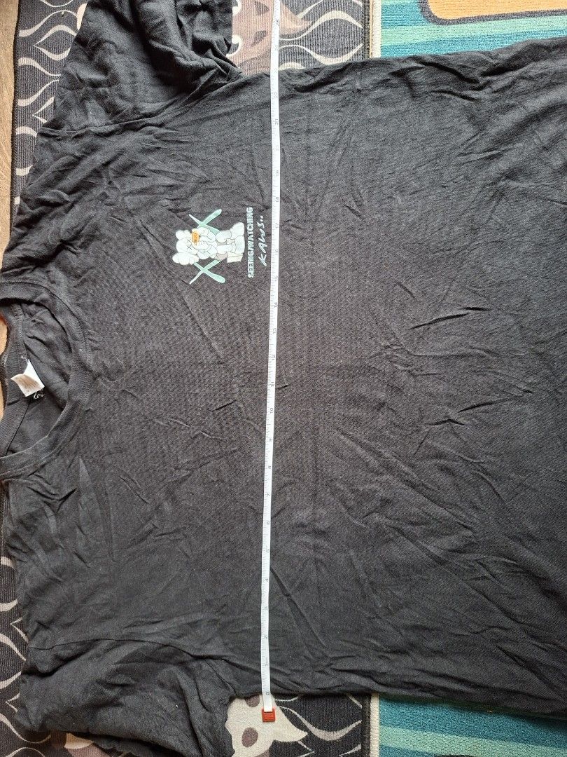 KAWS Seeing/Watching Black Graphic T-Shirt (Category: Tshirts & Polo Shirts ) located in San Francisco. Submitted by manu2025 (Listing ID 1469808257, Image 3). Description: - Color: Black - Design: KAWS Seeing/Watching graphics on chest and back with large MATCH lettering - Neckline: Classic crew neck - Width (Pit-to-Pit): Approx. 24 inches - Length (Shoulder to Hem): Approx. 27 inches - Condition: Good quality streetwear ready to wear plus 79 ph