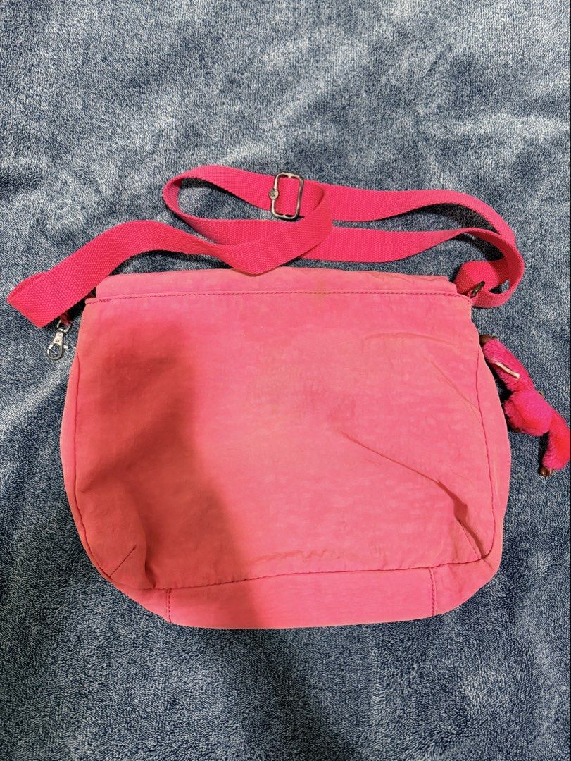 Kipling Pink Crossbody Bag with Monkey Keychain (Category: Cross-body Bags) located in Cavite. Submitted by mgd.blessed (Listing ID 1469911141, Image 2). Description: - Authentic Kipling crossbody bag in a vibrant bright pink shade - Includes the iconic furry pink monkey keychain - Features an adjustable pink fabric strap and front flap pocket with secure zipper closure - Silver-tone hardware accents - Interior has grey fabric lining with the off