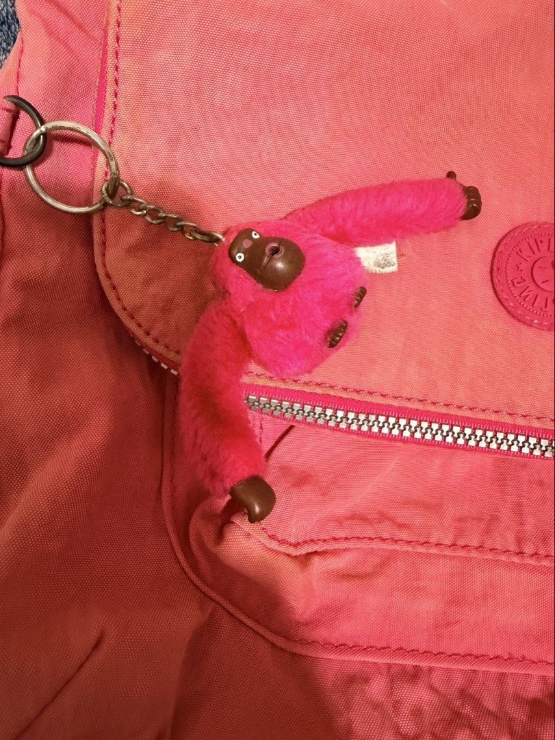 Kipling Pink Crossbody Bag with Monkey Keychain (Category: Cross-body Bags) located in Cavite. Submitted by mgd.blessed (Listing ID 1469911141, Image 1). Description: - Authentic Kipling crossbody bag in a vibrant bright pink shade - Includes the iconic furry pink monkey keychain - Features an adjustable pink fabric strap and front flap pocket with secure zipper closure - Silver-tone hardware accents - Interior has grey fabric lining with the off