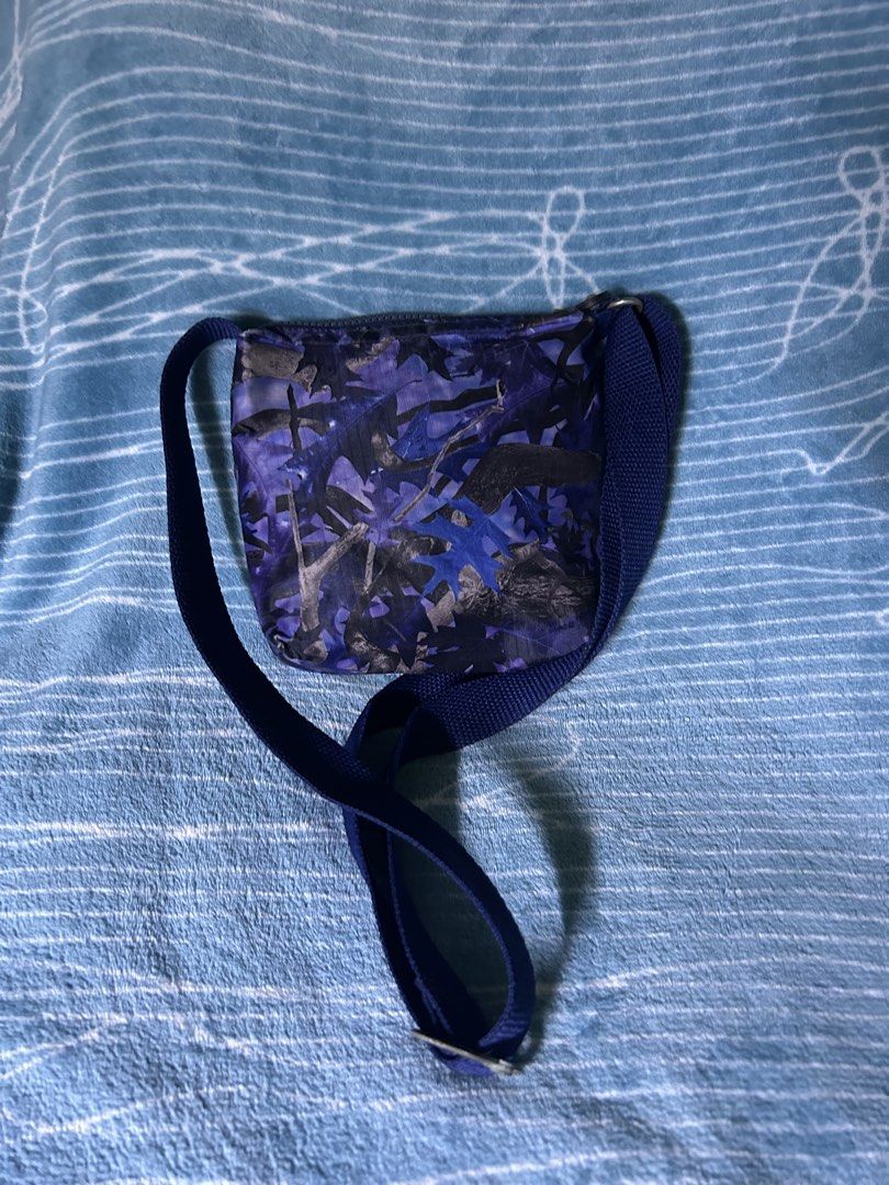 Kipling Purple Leaf Camo Crossbody Bag (Category: Cross-body Bags) located in Quezon City. Submitted by thriftxgoods (Listing ID 1469895661, Image 3). Description: - Design: Purple leaf camo pattern on durable nylon with a blue adjustable strap - Storage: Main zip compartment, 2 zippered front pockets, and an internal zippered side pocket - Interior: Cute grey lining with white polka dots and authentic Kipling brand tag - Size: Ideal for daily es