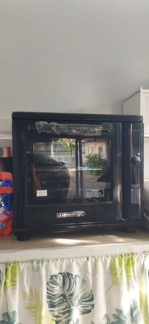 La Germania SL100 10B Electric Oven (Category: Ovens & Toasters) located in Manila. Submitted by charieeris13732 (Listing ID 1469833634, Image 2). Description: - Brand: La Germania (Model SL100 10B) - Color/Design: Sleek black finish with glass door - Features: Built-in temperature conversion chart on side control panel - Inclusions: Wire rack, product manual, and original box - Manufacturer: General Heat Corporation (under license from Bertazzon